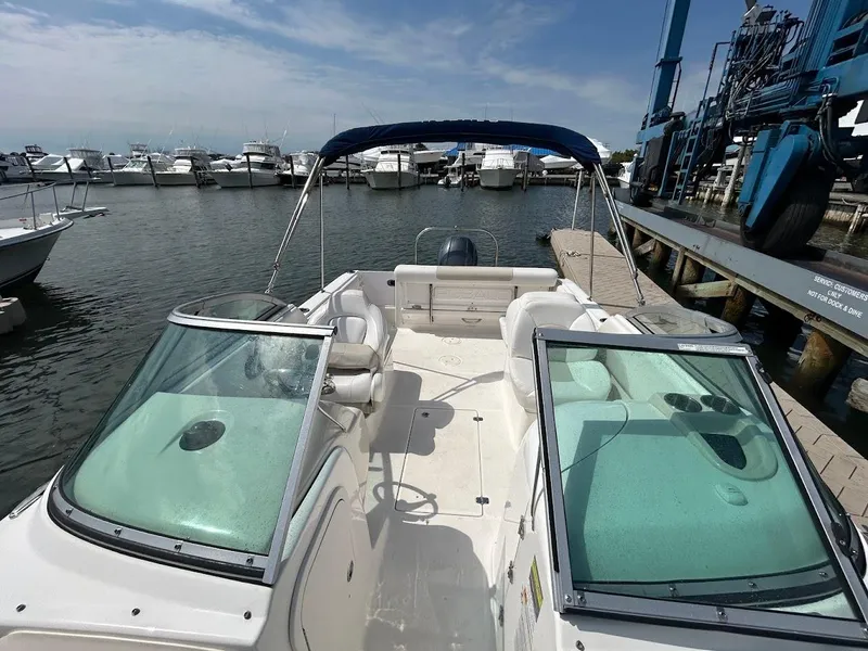 Slide: The Image of 2014 Robalo R227 boat docked at marina, featuring dual windshields and spacious seating. - 21
