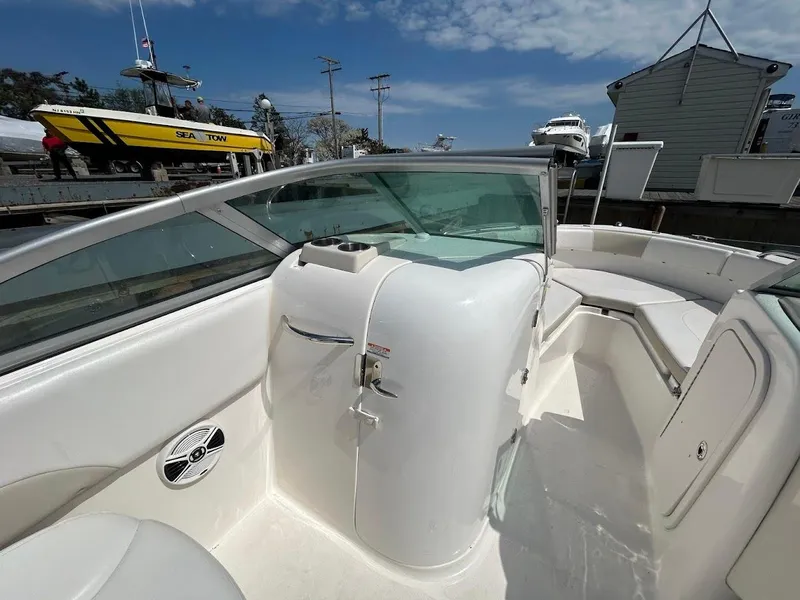 Slide: The Image of 2014 Robalo R227 boat interior with seating and storage, docked under a clear sky. - 23