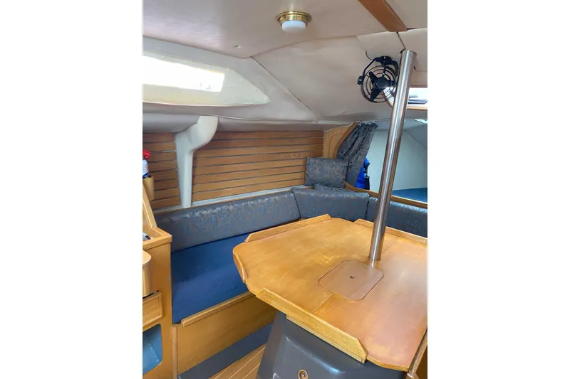Slide: The Image of Interior of 1988 Kirie 286 sailboat with wooden table and blue seating. - 11