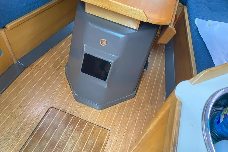 Slide: The Image of Interior of a 1988 Kirie 286 sailboat with wooden flooring and seating area. - 13