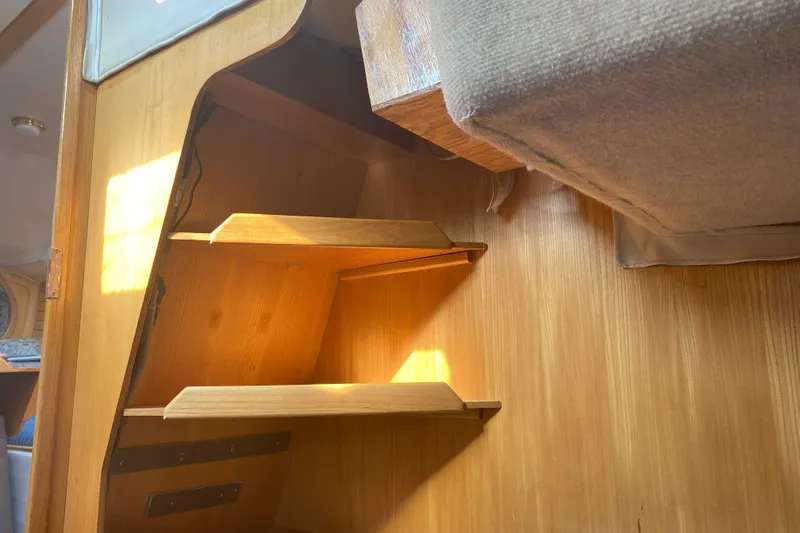 Slide: The Image of Interior of 1988 Kirie 286 sailboat with wooden shelves and cozy cabin design. - 16
