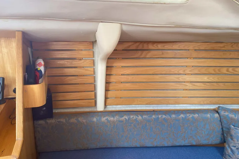 Slide: The Image of Interior of a 1988 Kirie 286 sailboat with wooden paneling and blue upholstery. - 22