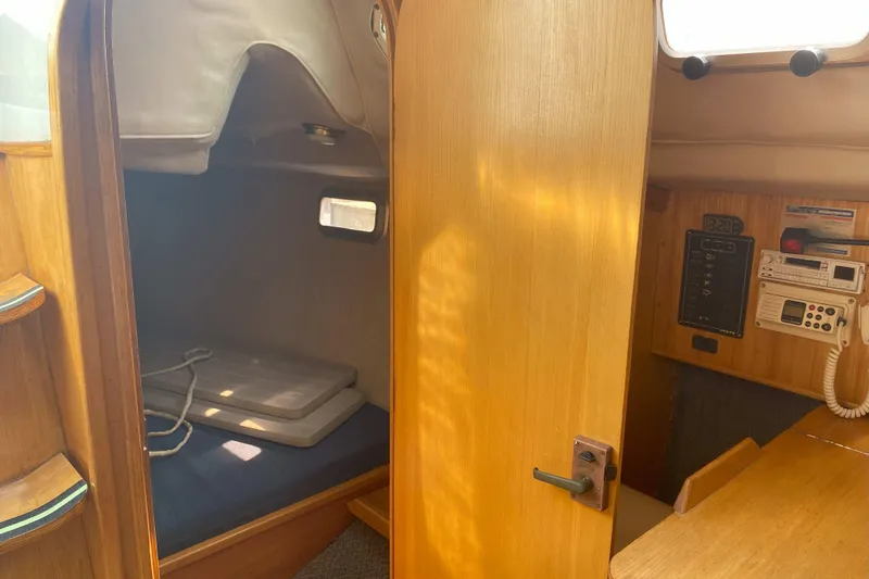 Slide: The Image of 1988 Kirie 286 sailboat interior with cabin, navigation equipment, and wooden furnishings. - 23