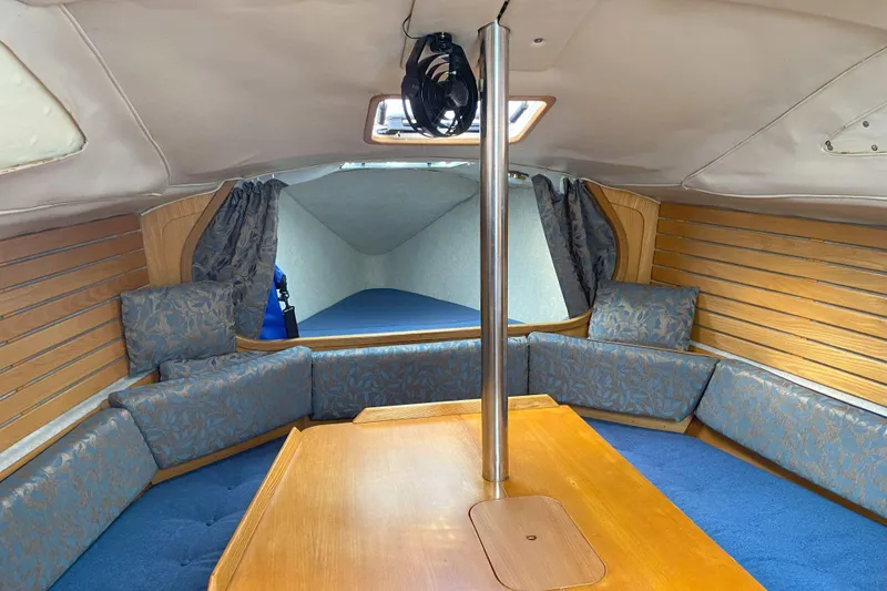 Slide: The Image of Interior of 1988 Kirie 286 sailboat with wooden table and cushioned seating. - 9