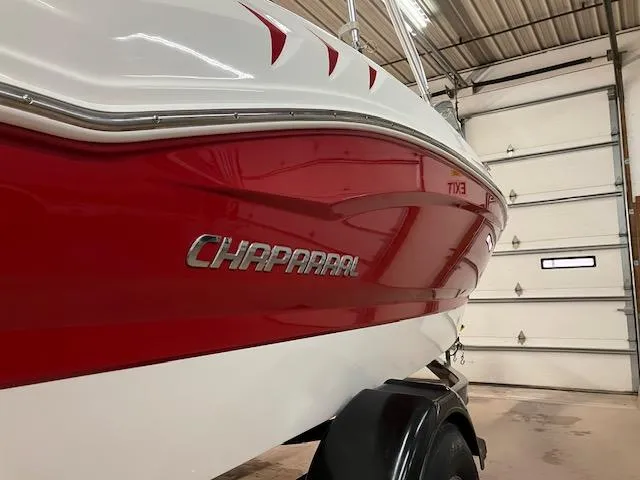 Slide: The Image of 2014 Chaparral 18 Sport H2O boat with red and white exterior in a garage. - 6