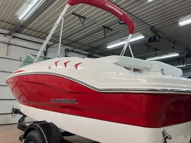 Slide: The Image of 2014 Chaparral 18 Sport H2O boat in a garage, featuring a red and white design. - 7
