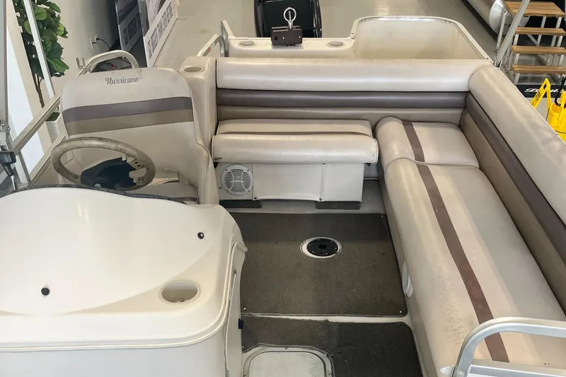 Slide: The Image of 1997 Hurricane 226 RE OB boat interior with beige seating and steering console. - 11