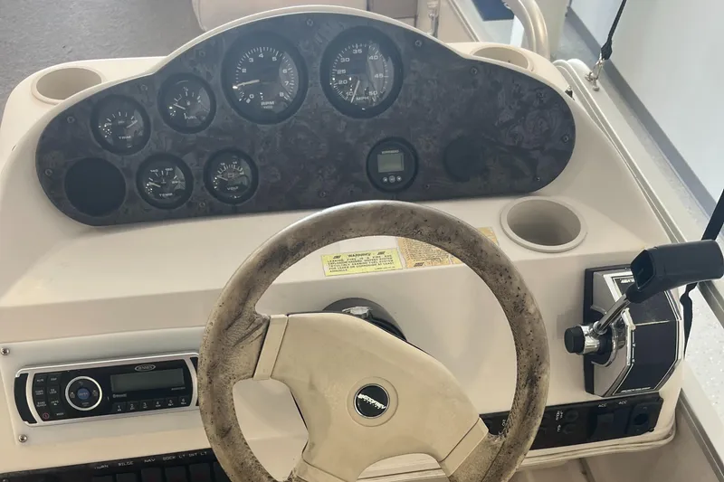 Slide: The Image of 1997 Hurricane 226 RE OB boat dashboard with steering wheel and control panel. - 12