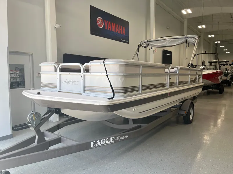 Slide: The Image of 1997 Hurricane 226 RE OB boat on trailer in showroom with Yamaha sign. - 3