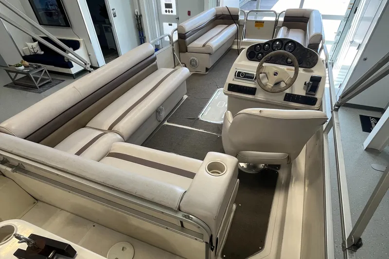 Slide: The Image of Interior of a 1997 Hurricane 226 RE OB boat with beige seating and steering console. - 7
