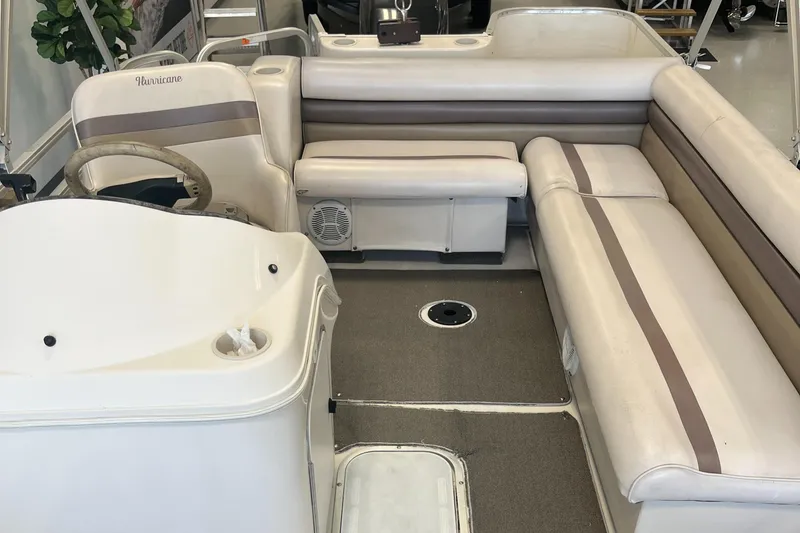 Slide: The Image of Interior of a 1997 Hurricane 226 RE OB boat with beige seating and steering console. - 8