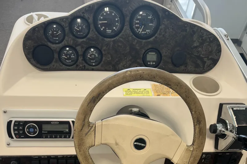 Slide: The Image of 1997 Hurricane 226 RE OB boat dashboard with steering wheel and instrument panel. - 9