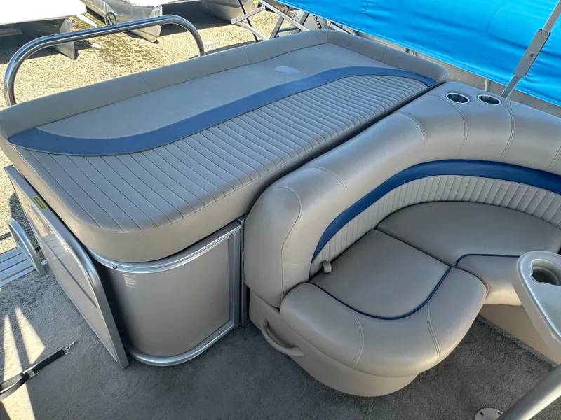 Slide: The Image of 2008 Godfrey AquaPatio 22 boat interior with gray and blue seating and storage area. - 13
