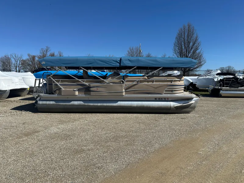 Slide: The Image of 2008 Godfrey AquaPatio 22 pontoon boat with blue canopy on gravel lot. - 2