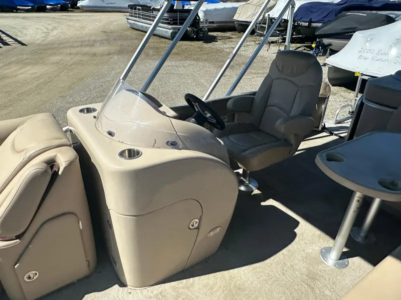 Slide: The Image of 2008 Godfrey AquaPatio 22 boat interior with beige seating and steering console. - 7