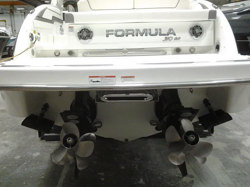 Slide: The Image of 2018 Formula 310 Bowrider boat stern with dual propellers in a showroom. - 11