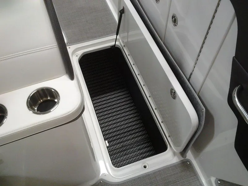 Slide: The Image of 2018 Formula 310 Bowrider storage compartment with open lid and cup holders. - 32