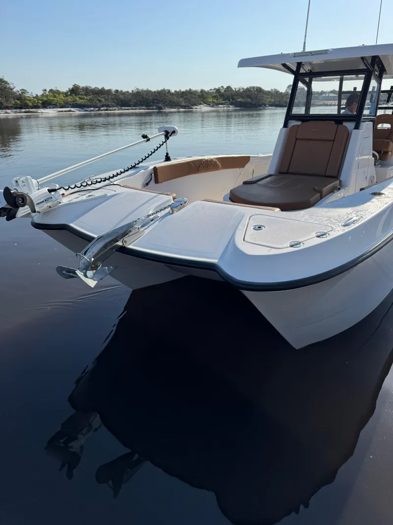 Slide: The Image of 2023 Twin Vee 280 GFX CC boat on calm water, showcasing sleek design and spacious seating. - 12