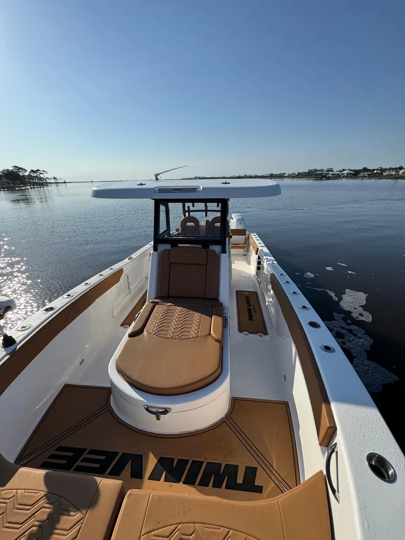 Slide: The Image of 2023 Twin Vee 280 GFX CC boat on calm water, sunny day, spacious deck. - 17