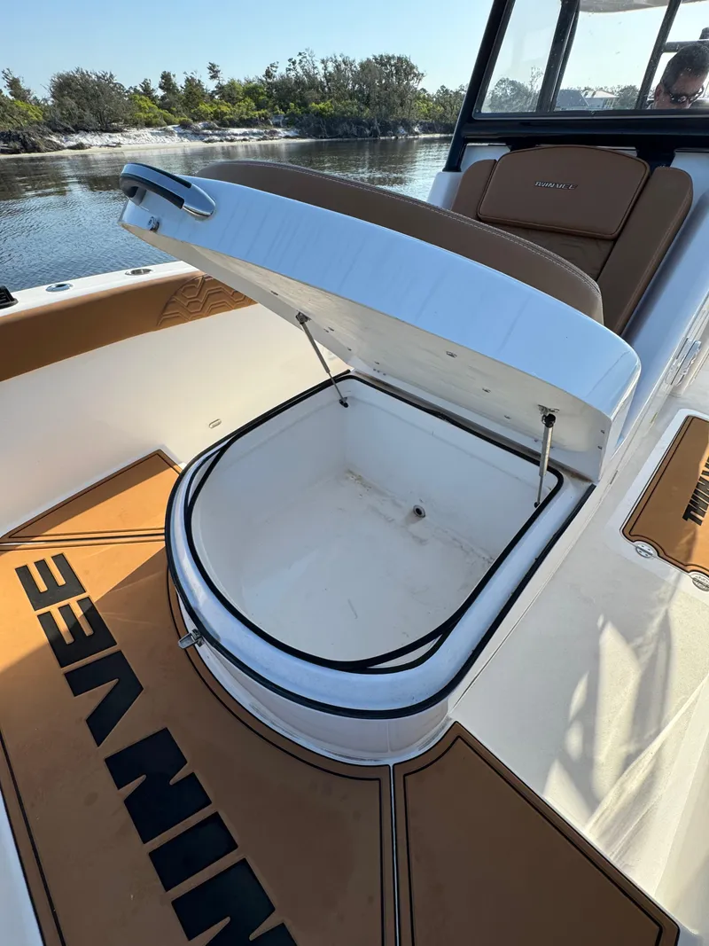 Slide: The Image of 2023 Twin Vee 280 GFX CC boat with open storage compartment on deck. - 24