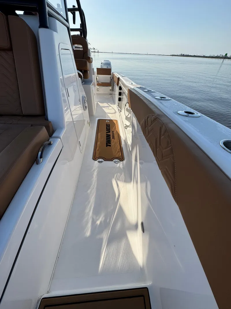 Slide: The Image of 2023 Twin Vee 280 GFX CC boat deck with seating, on calm water. - 27