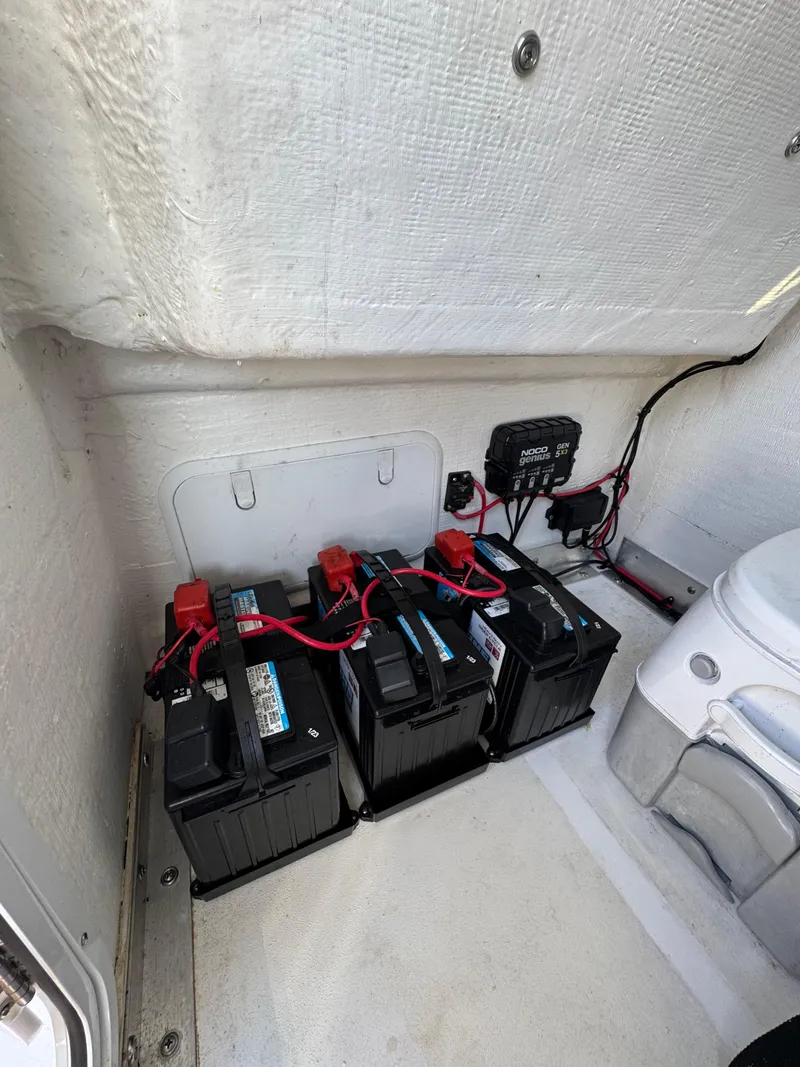 Slide: The Image of 2023 Twin Vee 280 GFX CC boat battery compartment with wiring and equipment. - 29
