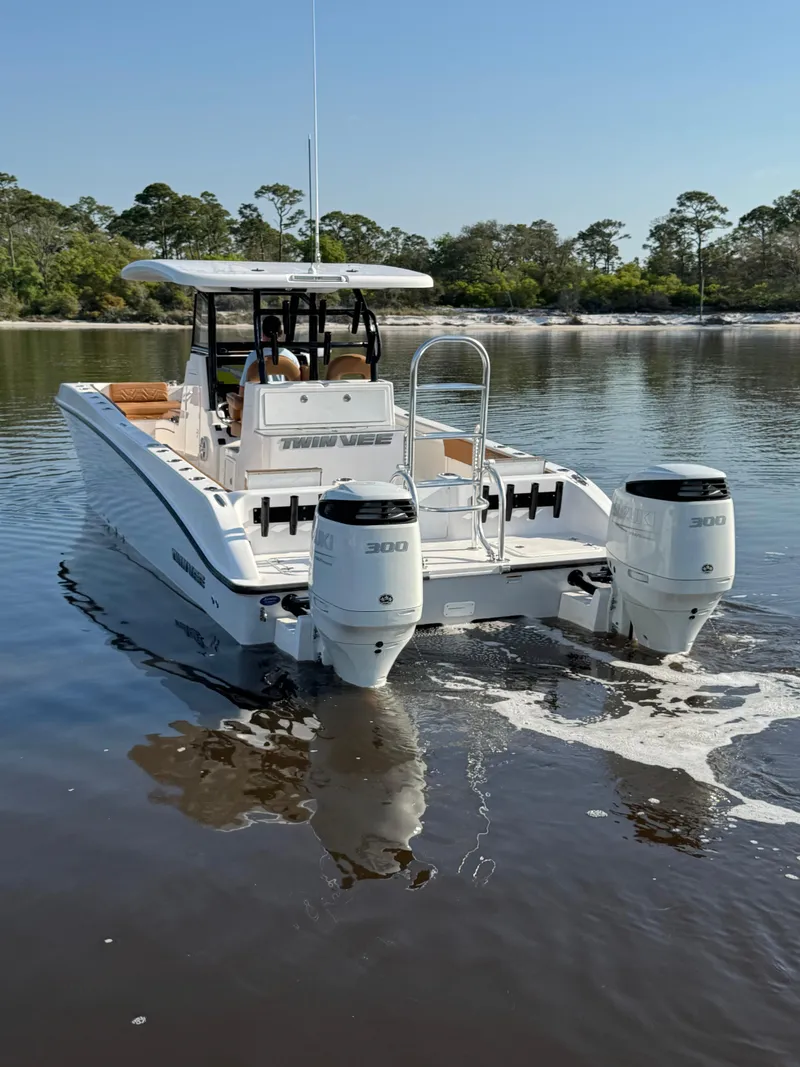 Slide: The Image of 2023 Twin Vee 280 GFX CC boat on calm water, rear view with dual engines. - 3