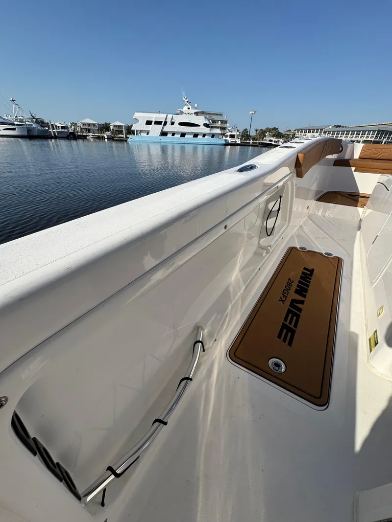 Slide: The Image of 2023 Twin Vee 280 GFX CC boat interior with docked yachts in background. - 34