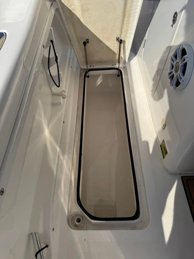 Slide: The Image of 2023 Twin Vee 280 GFX CC boat storage compartment with speaker and clean white interior. - 36