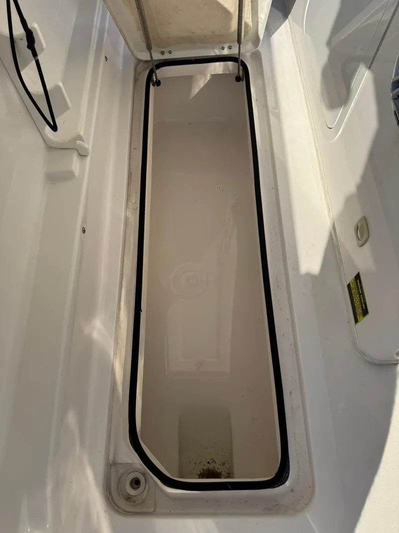 Slide: The Image of 2023 Twin Vee 280 GFX CC storage compartment, open and empty, with visible seal and latch. - 37