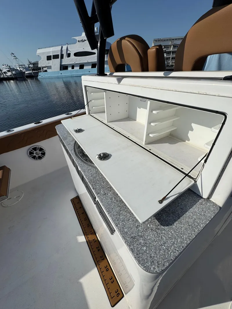 Slide: The Image of 2023 Twin Vee 280 GFX CC boat interior with open storage compartment, docked at marina. - 38