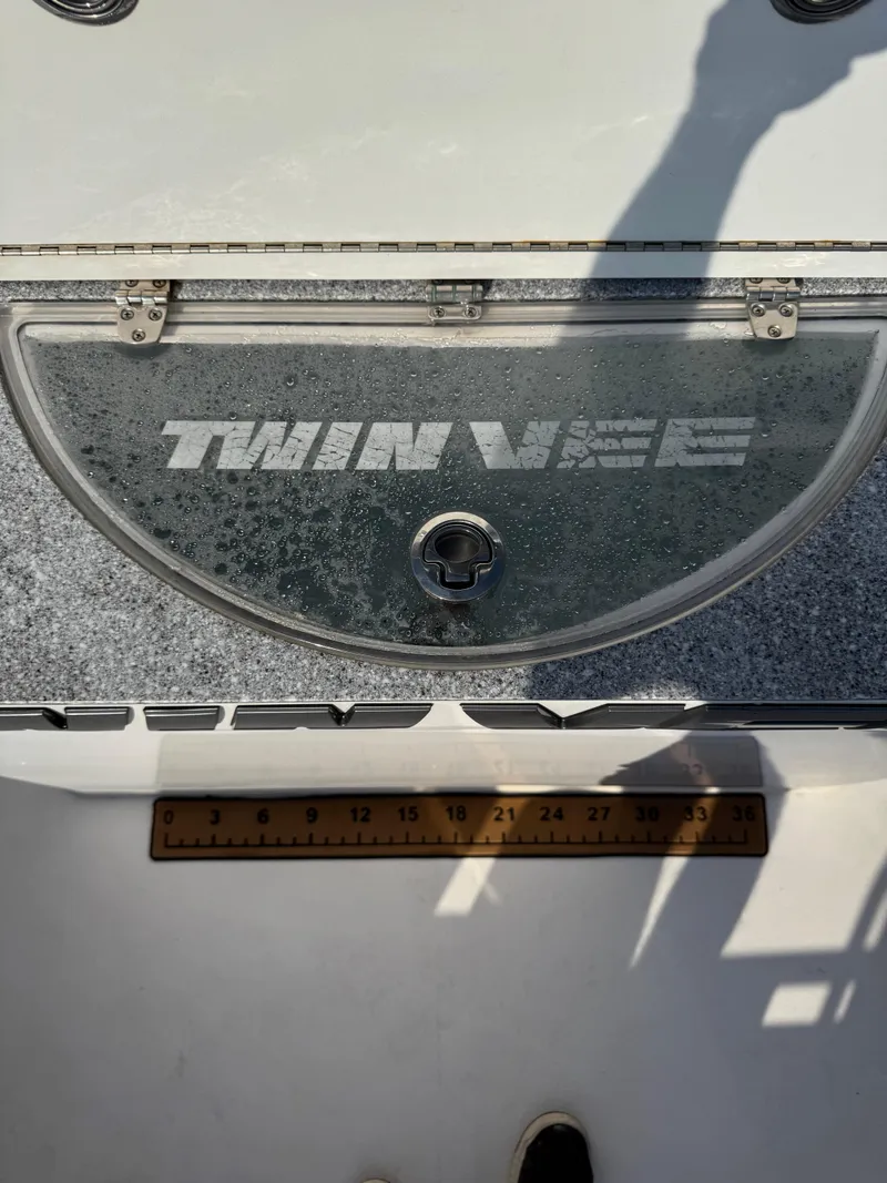Slide: The Image of 2023 Twin Vee 280 GFX CC boat deck with branded hatch and measuring ruler. - 40