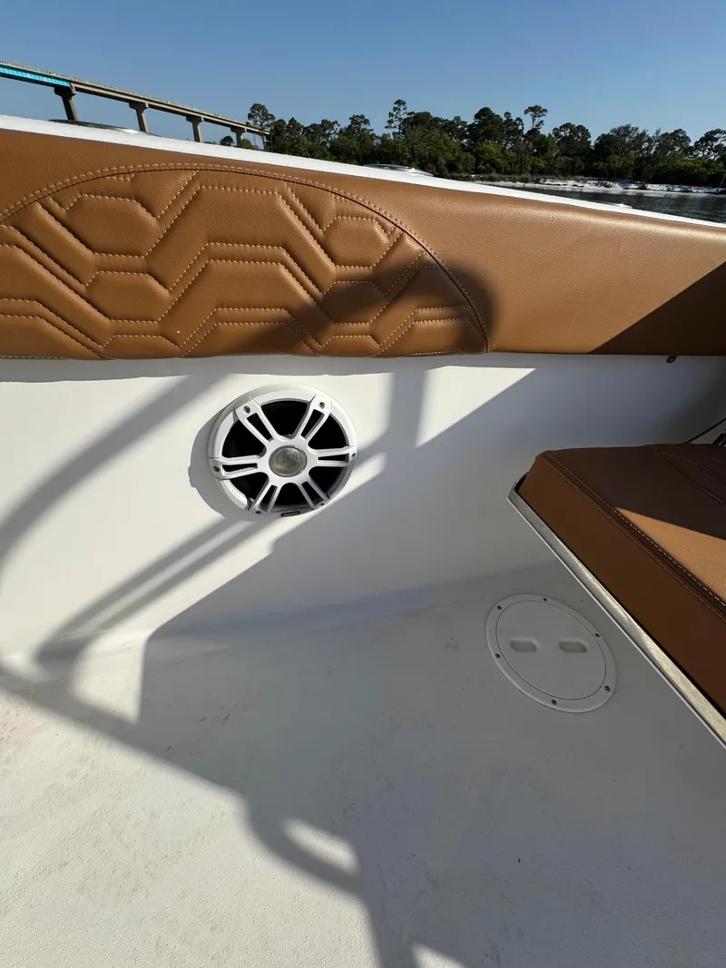 Slide: The Image of 2023 Twin Vee 280 GFX CC boat interior with tan seating and speaker. - 41