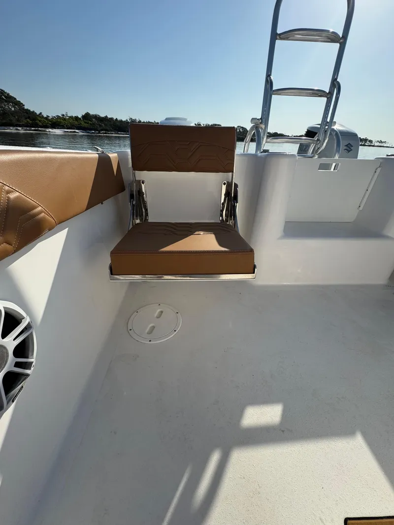 Slide: The Image of 2023 Twin Vee 280 GFX CC boat interior with seating and ladder, on calm water. - 42