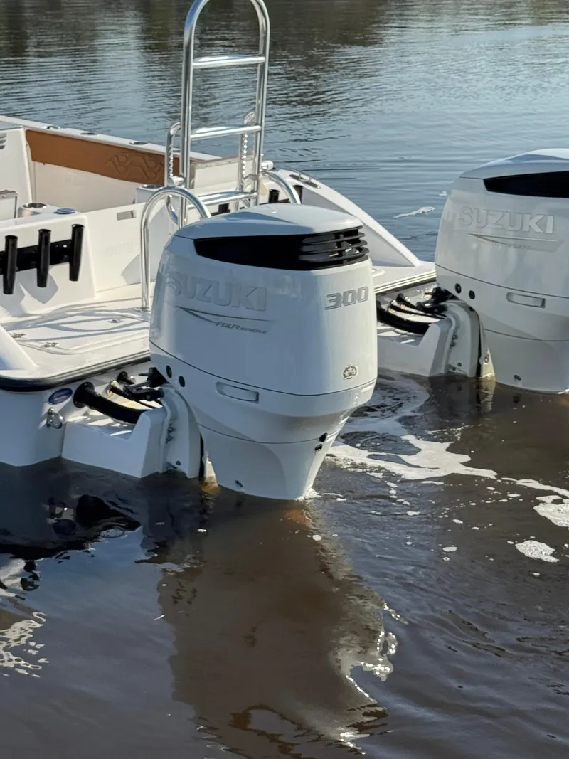 Slide: The Image of 2023 Twin Vee 280 GFX CC boat with dual Suzuki outboard motors in water. - 6