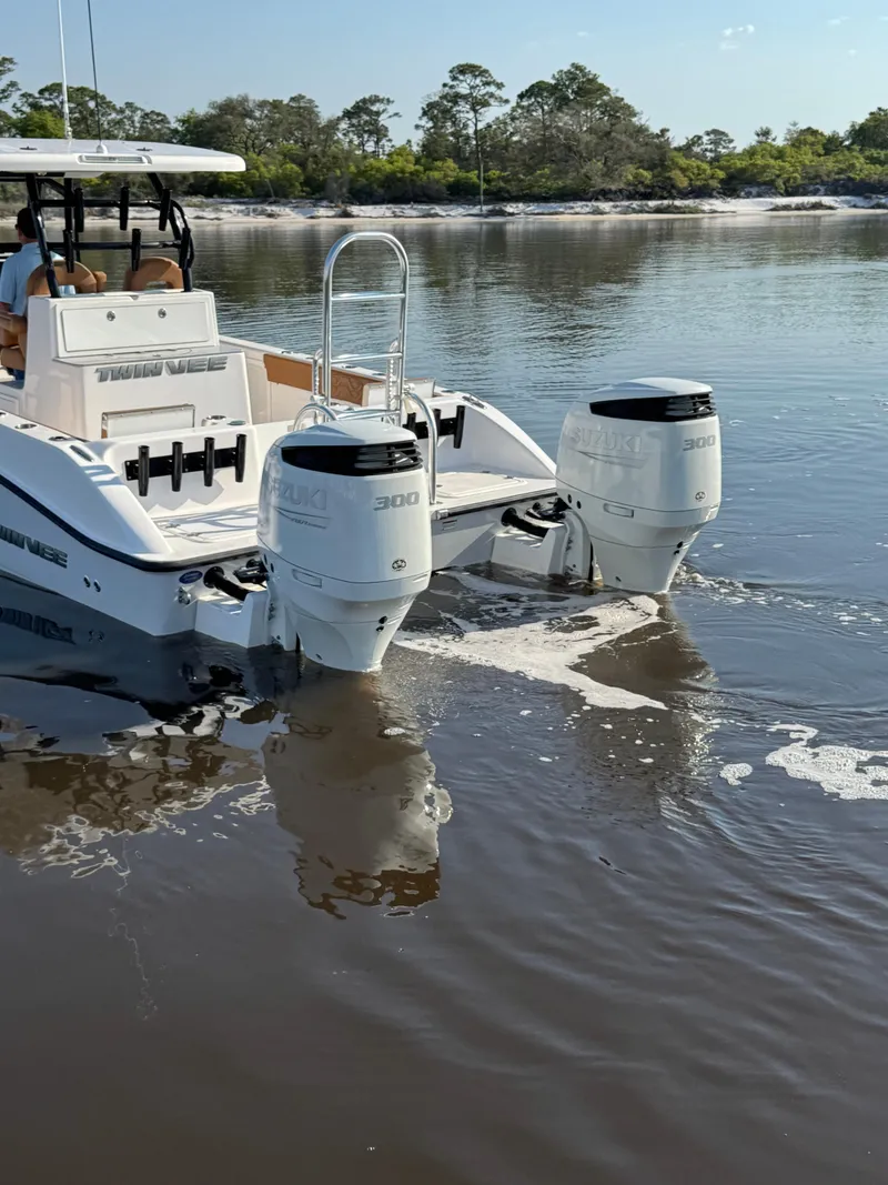 Slide: The Image of 2023 Twin Vee 280 GFX CC boat with dual engines on calm water. - 7