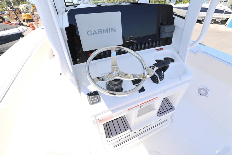 Slide: The Image of 2025 Sea Hunt Gamefish 27 helm with Garmin display and stainless steel steering wheel. - 16