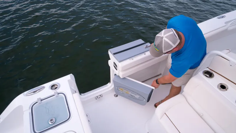Slide: The Image of 2025 Sea Hunt Gamefish 27 boat with forward seating, person accessing storage compartment. - 29