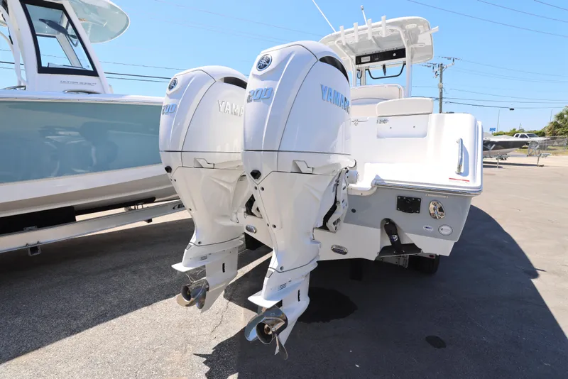 Slide: The Image of 2025 Sea Hunt Gamefish 27 with dual Yamaha outboard engines, parked on a sunny day. - 6