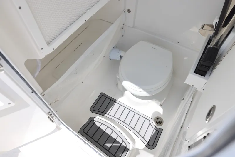 Slide: The Image of 2025 Sea Hunt Gamefish 27 boat interior with compact marine toilet and non-slip flooring. - 7