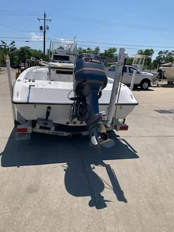 Slide: The Image of 2004 Champion 22 Bay Champ boat with outboard motor, parked on a sunny day. - 3
