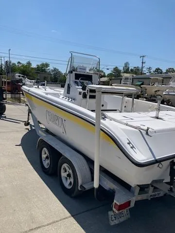 Slide: The Image of 2004 Champion 22 Bay Champ boat on trailer, parked outdoors on a sunny day. - 4