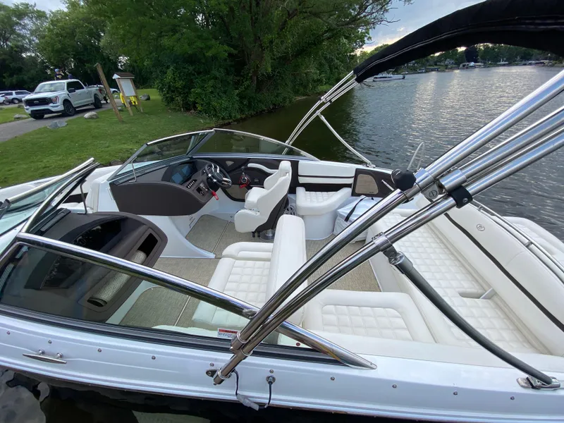 Slide: The Image of 2018 Cobalt R3 boat with white interior, docked by a scenic lakeside. - 4
