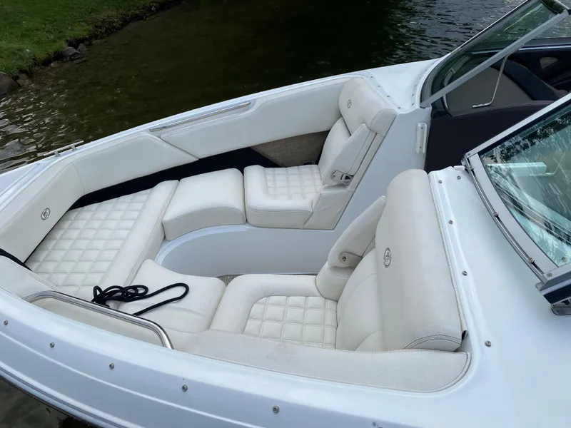 Slide: The Image of 2018 Cobalt R3 boat with white leather seating, docked by a lake. - 6