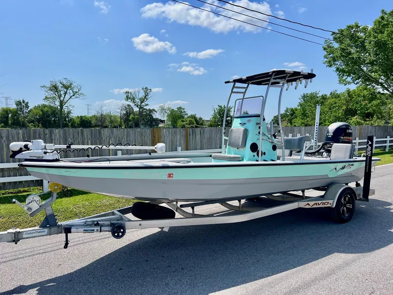 Slide: The Image of 2022 Avid 21 FS boat on trailer, parked on a sunny street. - 1