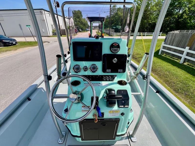 Slide: The Image of 2022 Avid 21 FS boat console with steering wheel and controls, parked on a street. - 11