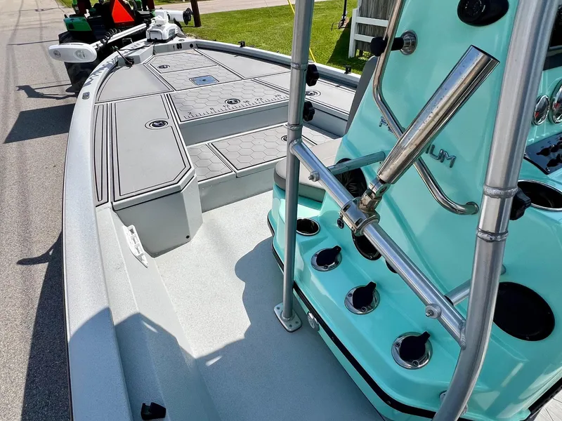 Slide: The Image of 2022 Avid 21 FS boat interior with teal console and rod holders. - 12