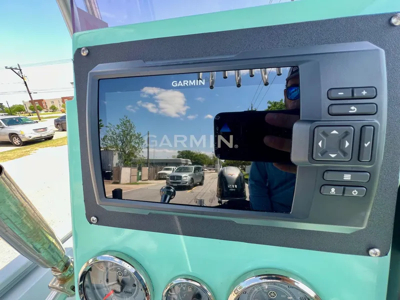 Slide: The Image of Garmin display on 2022 Avid 21 FS boat dashboard, reflecting outdoor scene. - 16