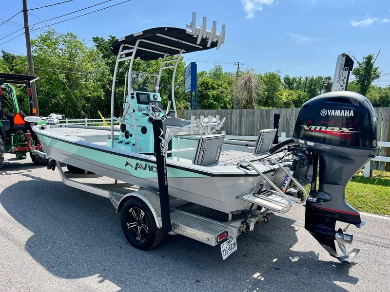 Slide: The Image of Avid 21 FS 2022 boat with Yamaha VMAX engine on trailer, parked outdoors. - 2