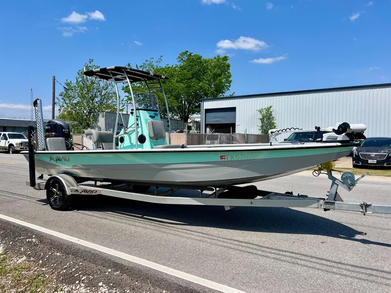 Slide: The Image of 2022 Avid 21 FS boat on trailer, parked outdoors under a clear blue sky. - 5